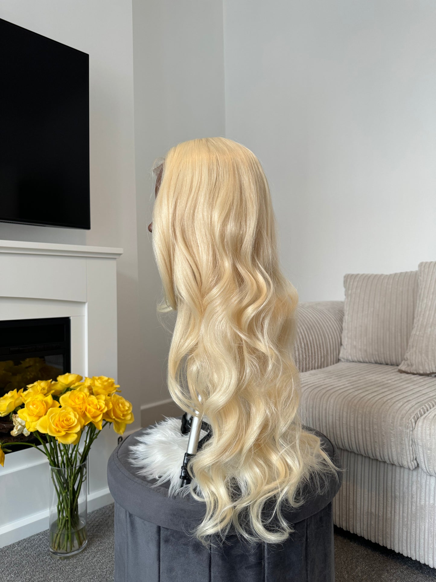 product Side view of a curly blonde wig with a lace front, showcasing the bouncy curls and natural-looking finish