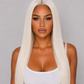 PRODUCT A woman with long, straight platinum blonde hair parted down the middle, wearing a white tank top against a solid gray studio background.