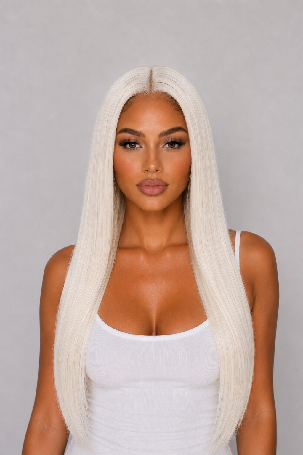 PRODUCT A woman with long, straight platinum blonde hair parted down the middle, wearing a white tank top against a solid gray studio background.