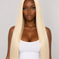 A woman with long, straight, platinum blonde hair extensions wearing a white tank top and blue jeans, photographed against a solid light gray background.