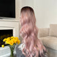 product: Full view of a long pink wavy lace front wig, highlighting the vibrant color and realistic texture