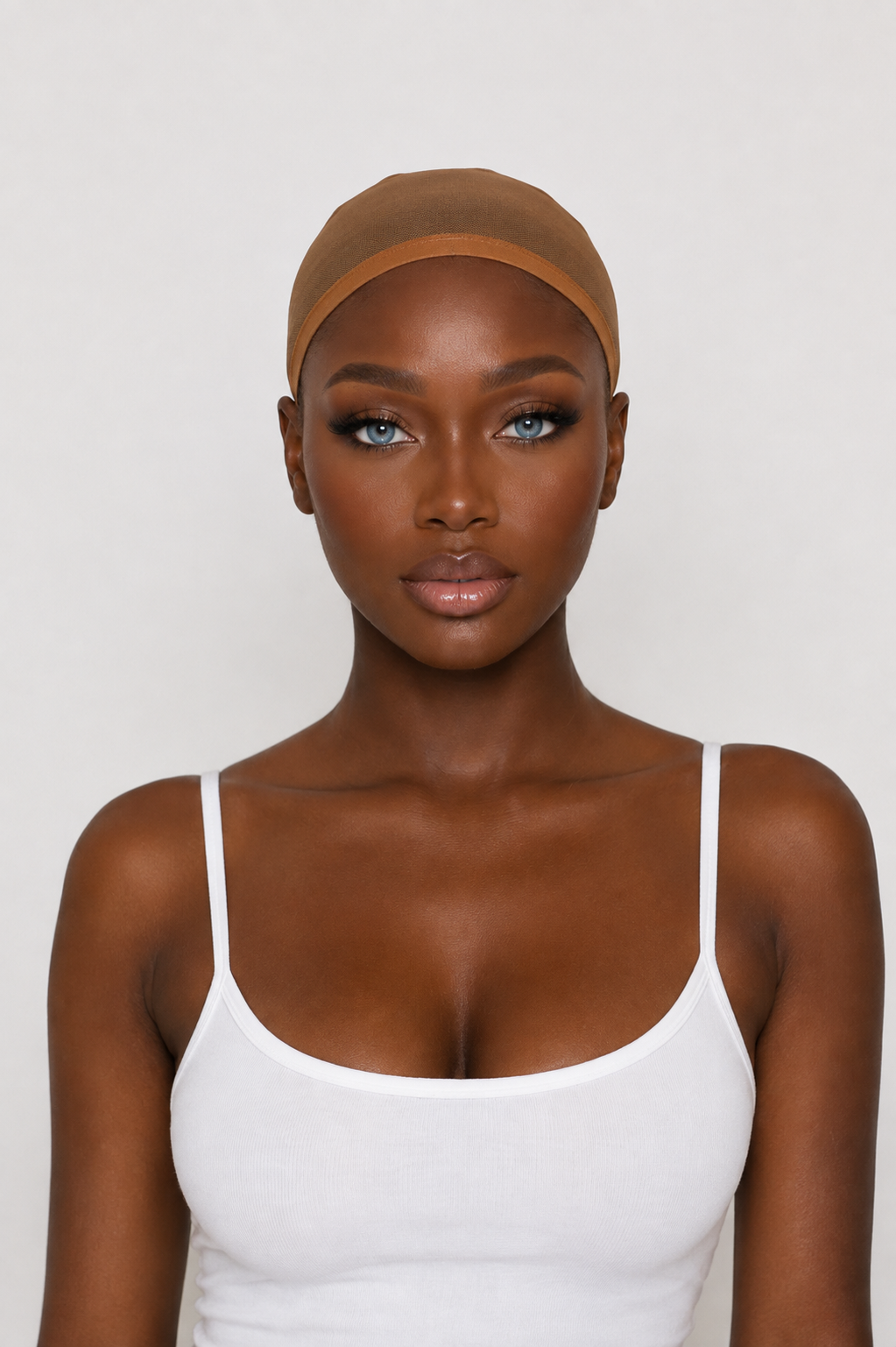 A woman wearing a sheer, skin-toned silicone or latex cap against a plain light gray background.