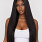 A woman modeling a long, straight, black wig with a center part against a light gray studio background. product