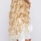 synthetic blonde curly hair wig from pbeauty hair being worn by model wearing a white top